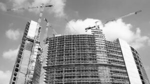 A black and white image of a tall building being constructed